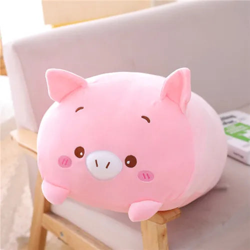 Soft pink plush pig toy with small ears, snout, and rosy cheeks, sitting on a chair.