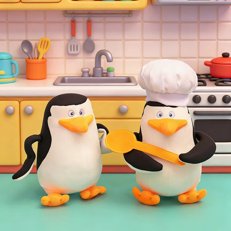 Soft plush Madagascar penguin toy, 28cm, one wearing a chef's hat, in a colorful kitchen.