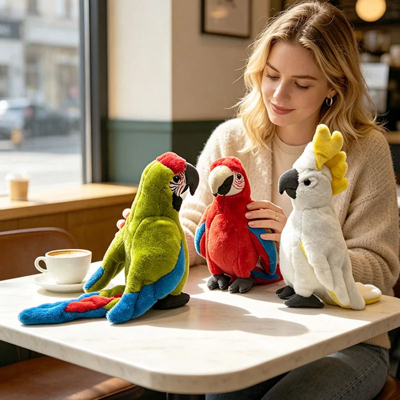 Woman admiring three soft, lifelike plush parrots: green, red, and white cockatoo, on a cafe table.