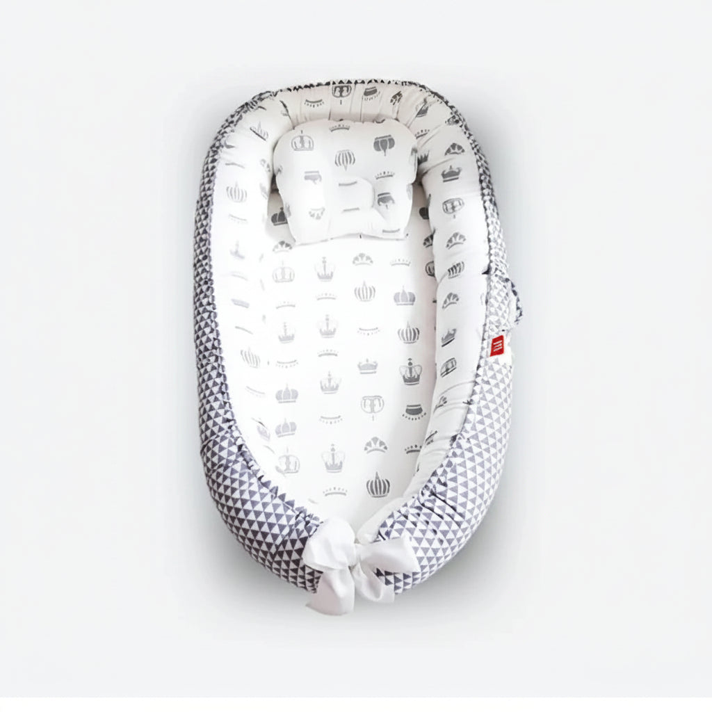 Adjustable baby nest sleeper with gray geometric and crown patterns, showing dimensions.