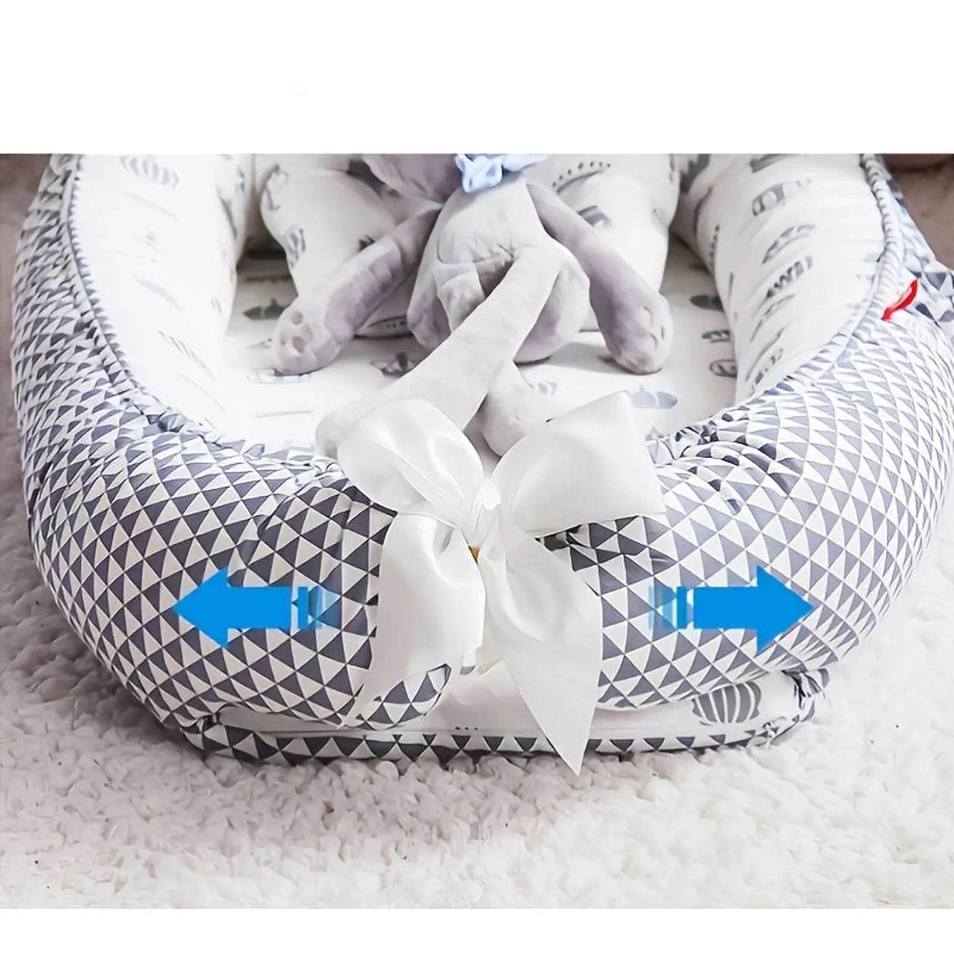 Adjustable baby nest with gray geometric pattern, white bow, and detachable cover.