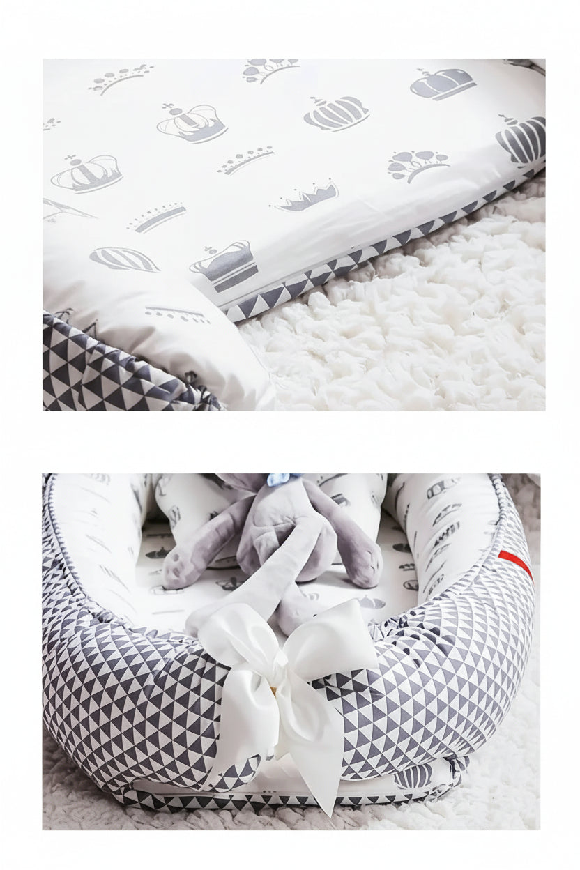 White baby nest with gray crown and geometric patterns, removable cover, and adjustable tail strap.