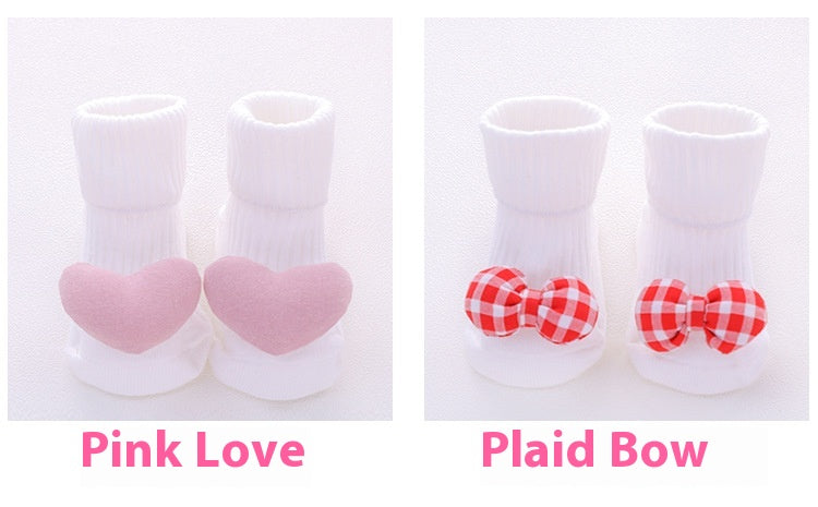 White cotton baby socks with pink hearts and red plaid bows, featuring non-slip soles.