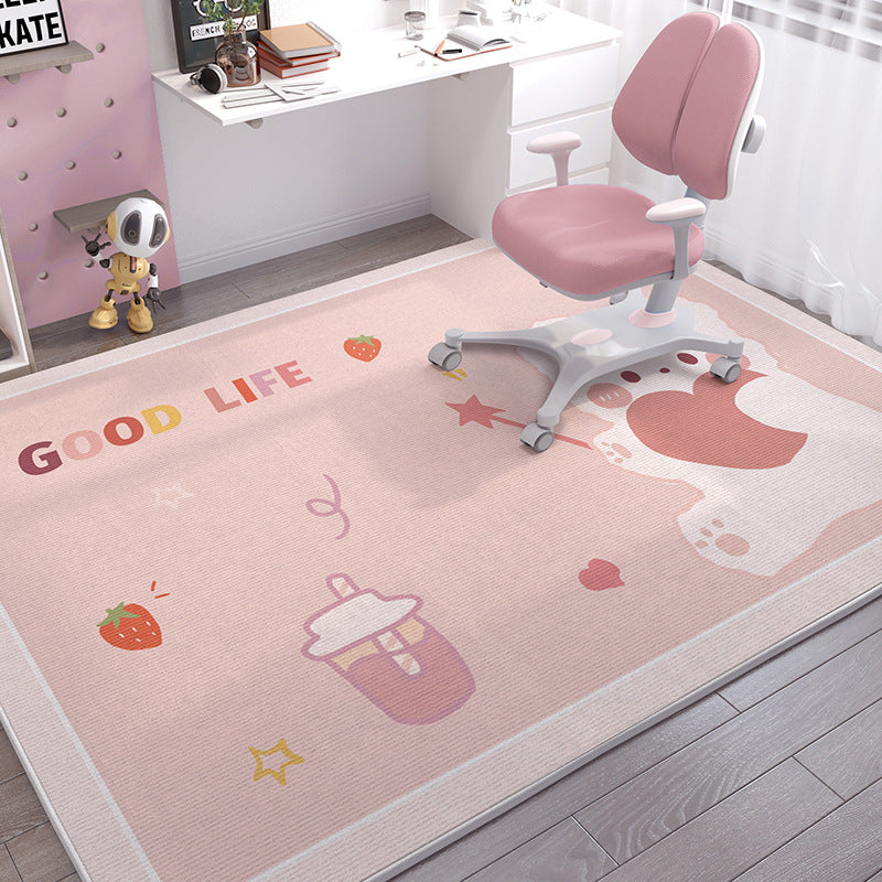 Soft pink crystal velvet kids' rug with "GOOD LIFE" text, strawberries, and cartoon designs, under a pink desk chair.
