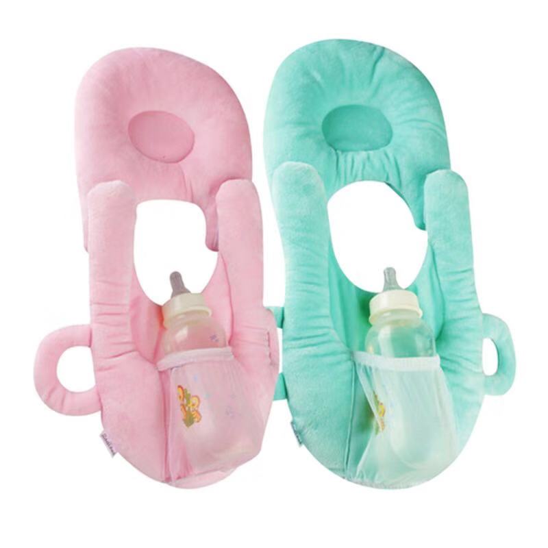 Pink and mint green velvet baby feeding pillows with ergonomic design and bottle holders.