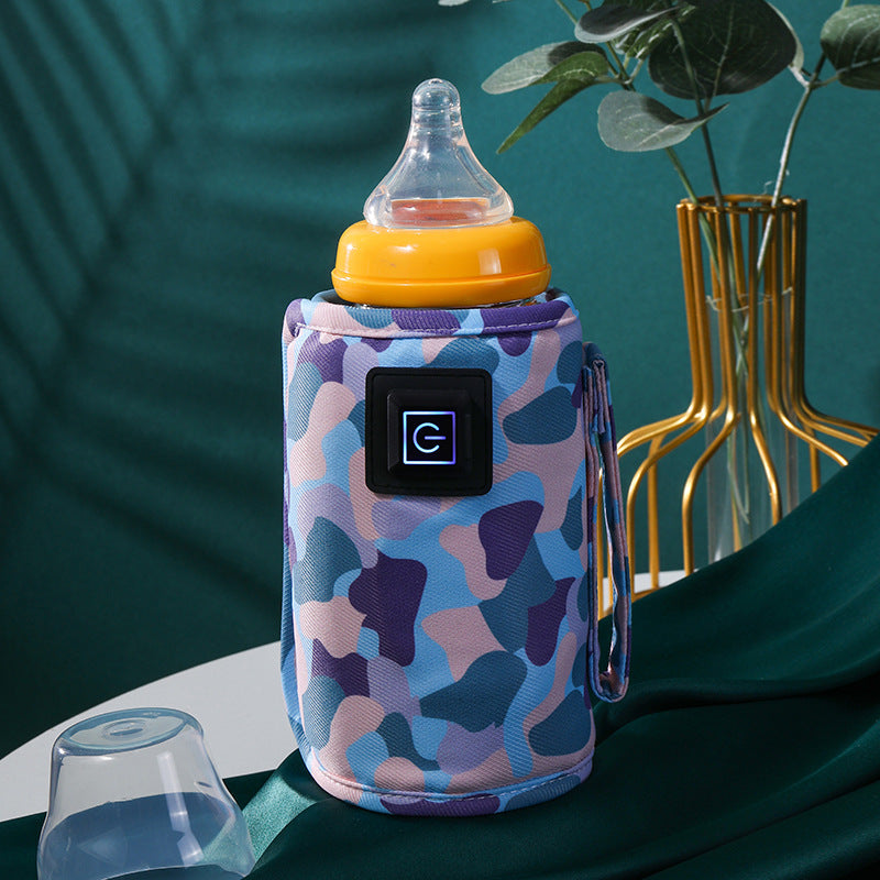 Portable baby bottle warmer with blue camouflage fabric, USB power button, and yellow-capped bottle.