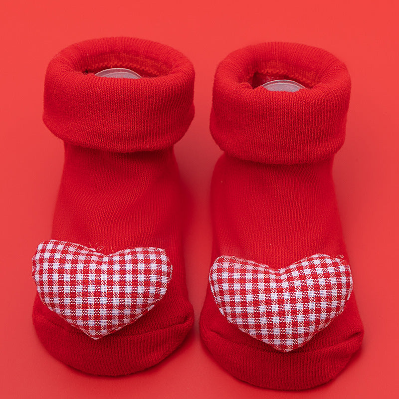Red cotton baby socks with white and red gingham heart appliques, featuring non-slip soles.