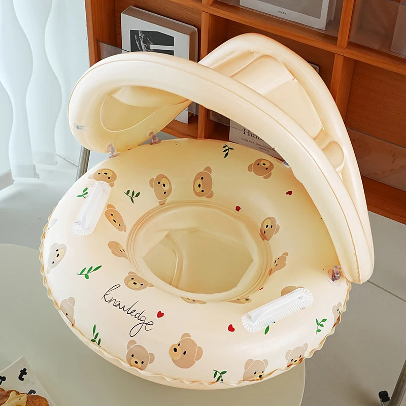 Beige inflatable baby swimming float with sun canopy, bear print, and "knowledge" text.