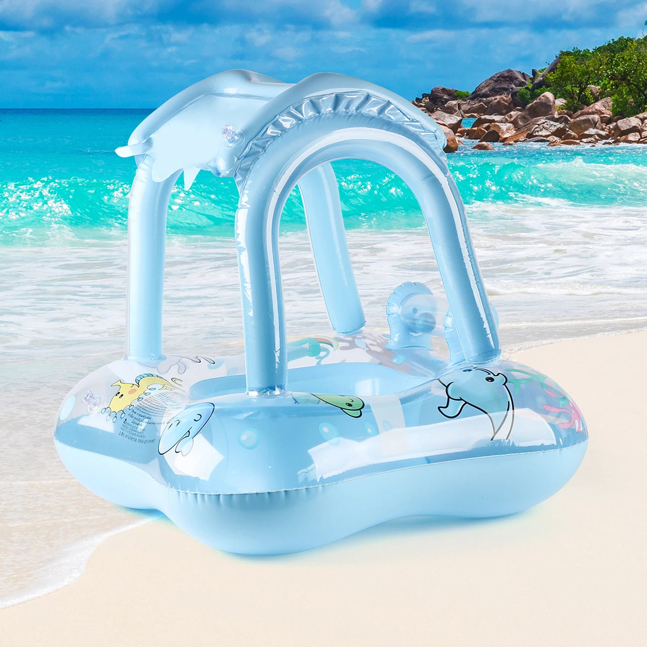 Blue inflatable baby swim float with sun canopy and sea animal designs on a beach.