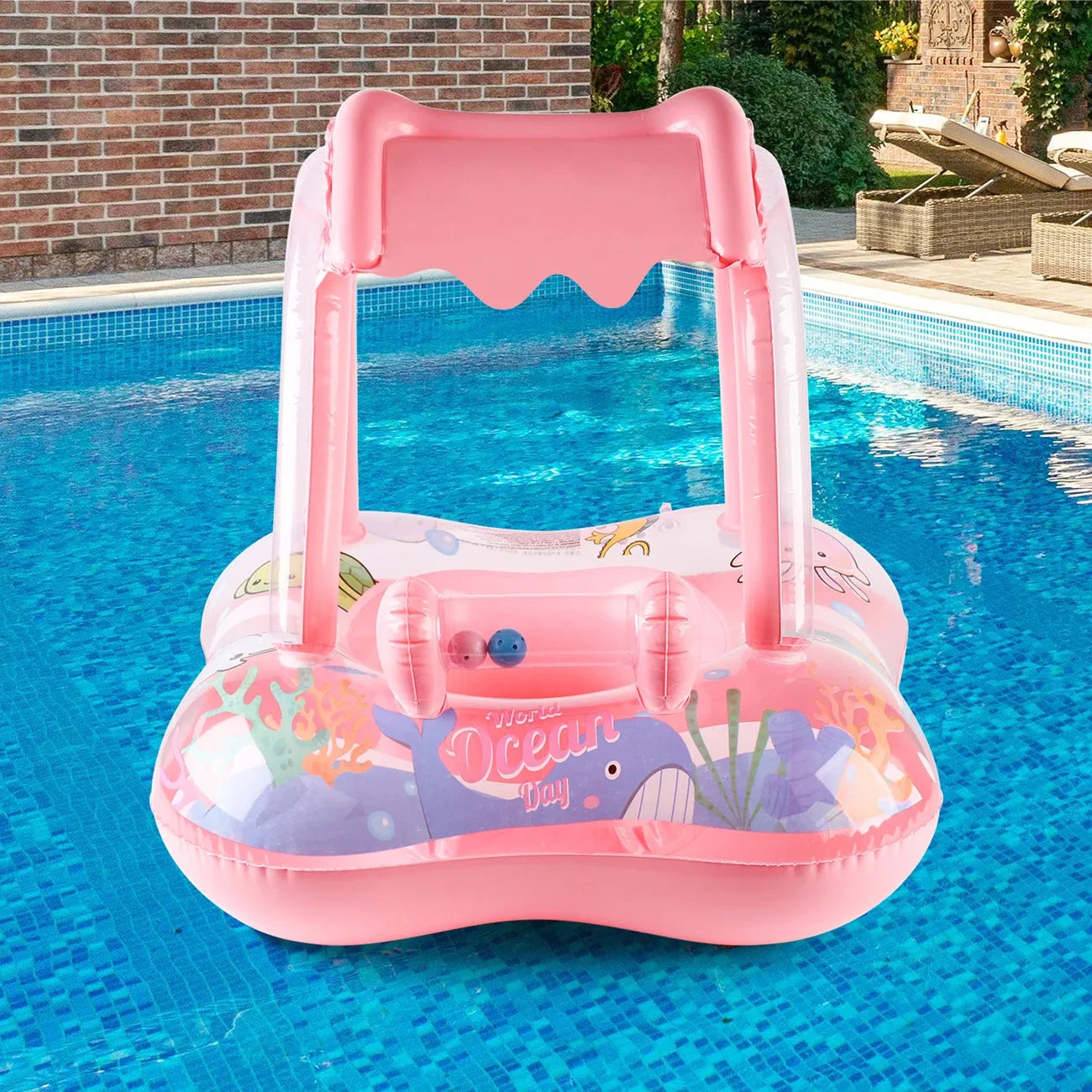 Pink inflatable kids' swim float with sun canopy, ocean graphics, and handles in a pool.