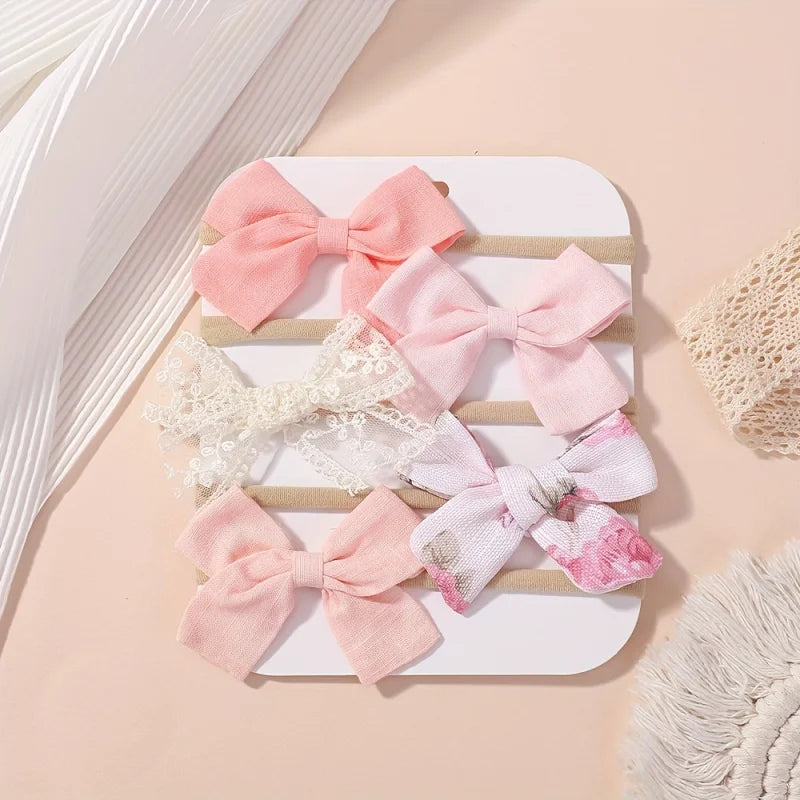 Set of 5 baby headbands with pink fabric bows, white lace, and floral patterns on soft nylon.