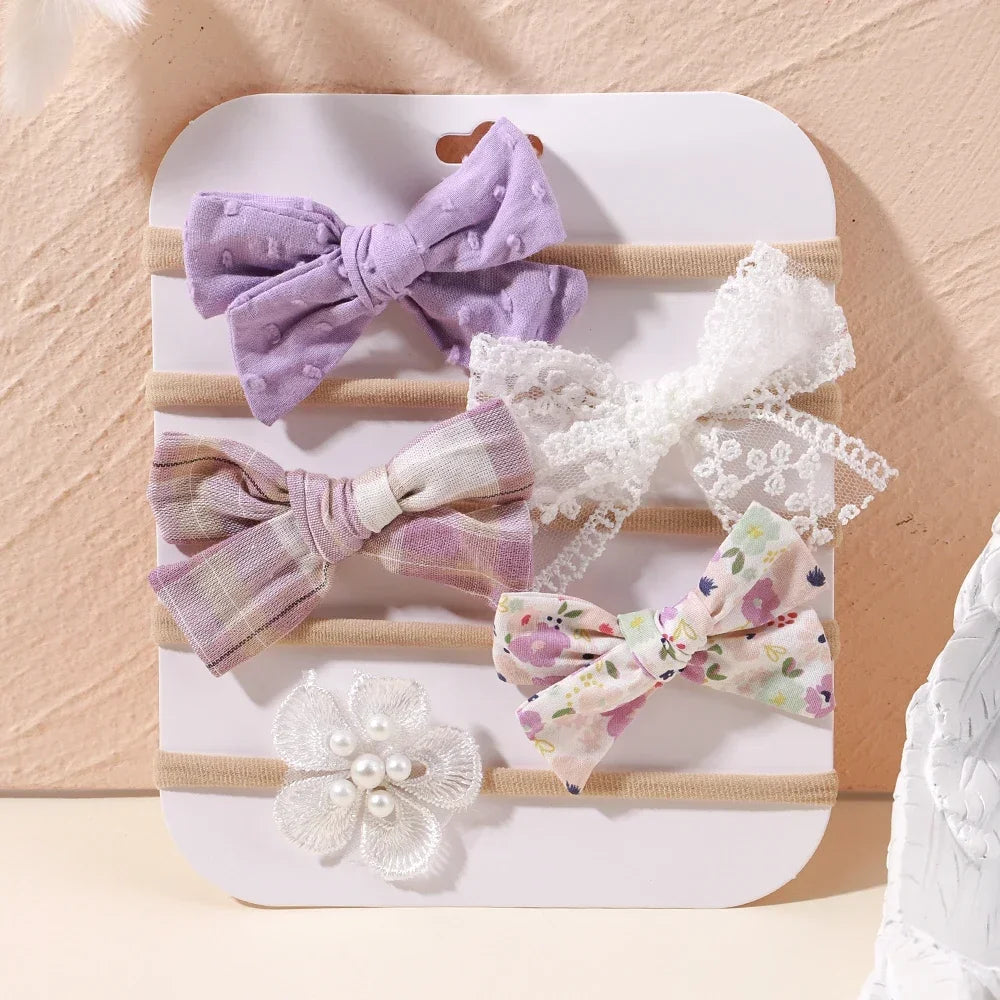 Set of 5 baby headbands: lavender bow, white lace, plaid, floral, and white lace flower with pearls.