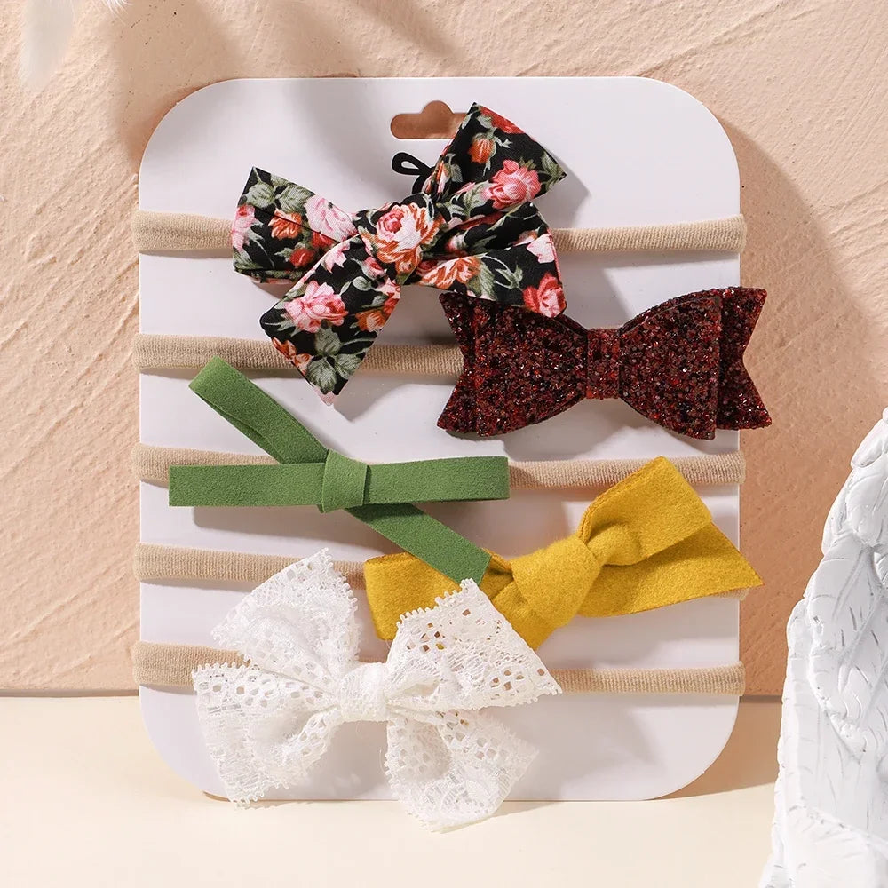 Set of 5 baby headbands with lace flowers, floral fabric, glitter, and solid bows in various colors.