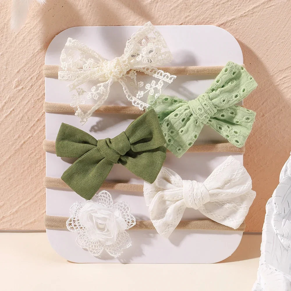 Set of 5 baby headbands with lace bows, green fabric bows, and a white lace flower.