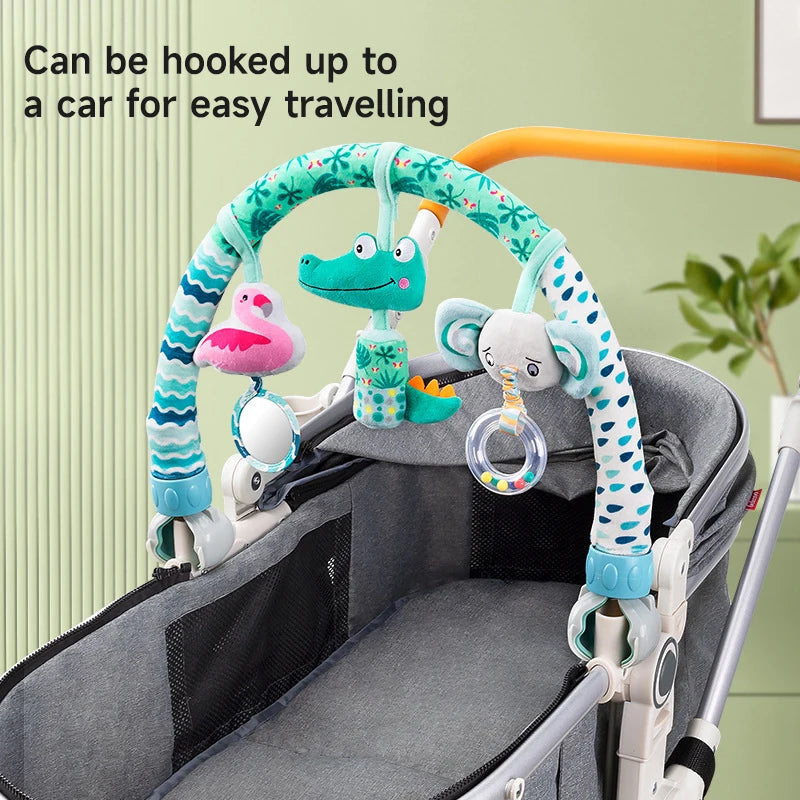 Adjustable baby activity arch with plush flamingo, crocodile, and elephant toys, attached to a gray stroller.