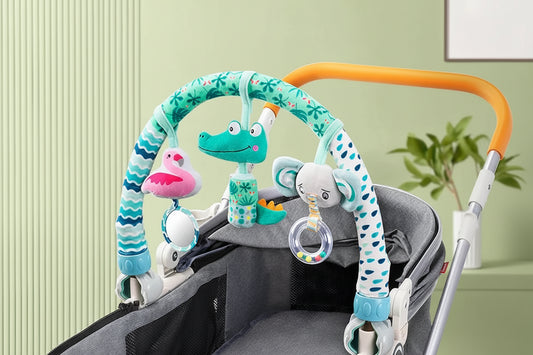Adjustable baby activity arch with plush crocodile, flamingo, and elephant toys, attached to a gray stroller.