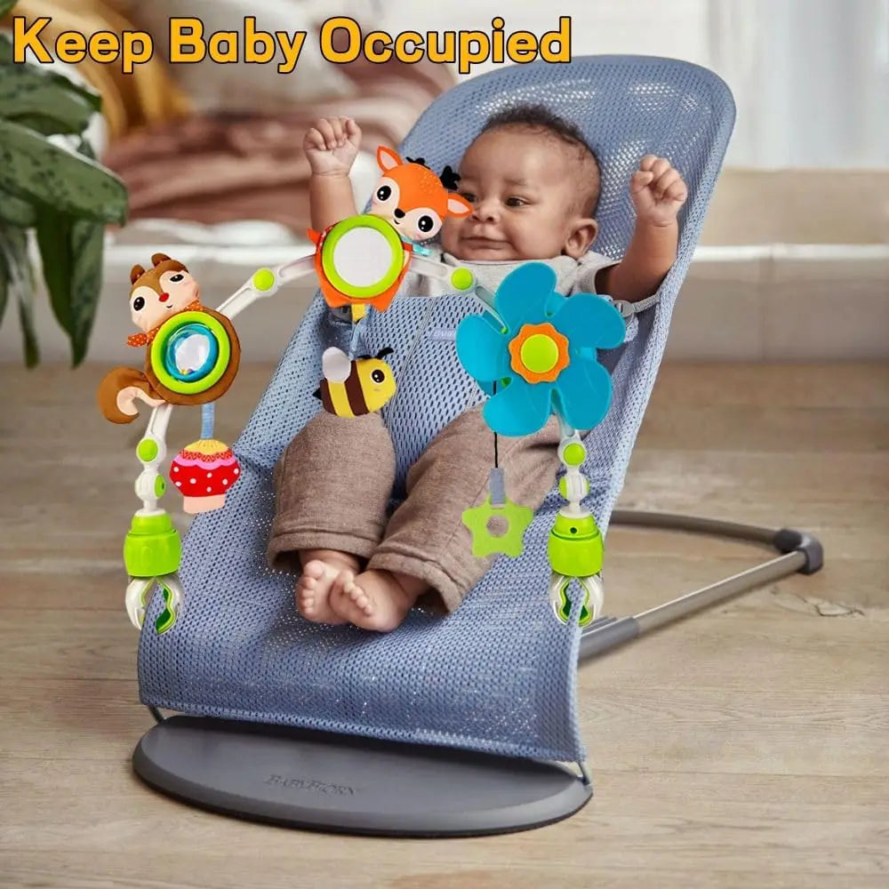 Baby in a blue bouncer playing with a colorful activity arch featuring a fox, squirrel, bee, and flower toys.