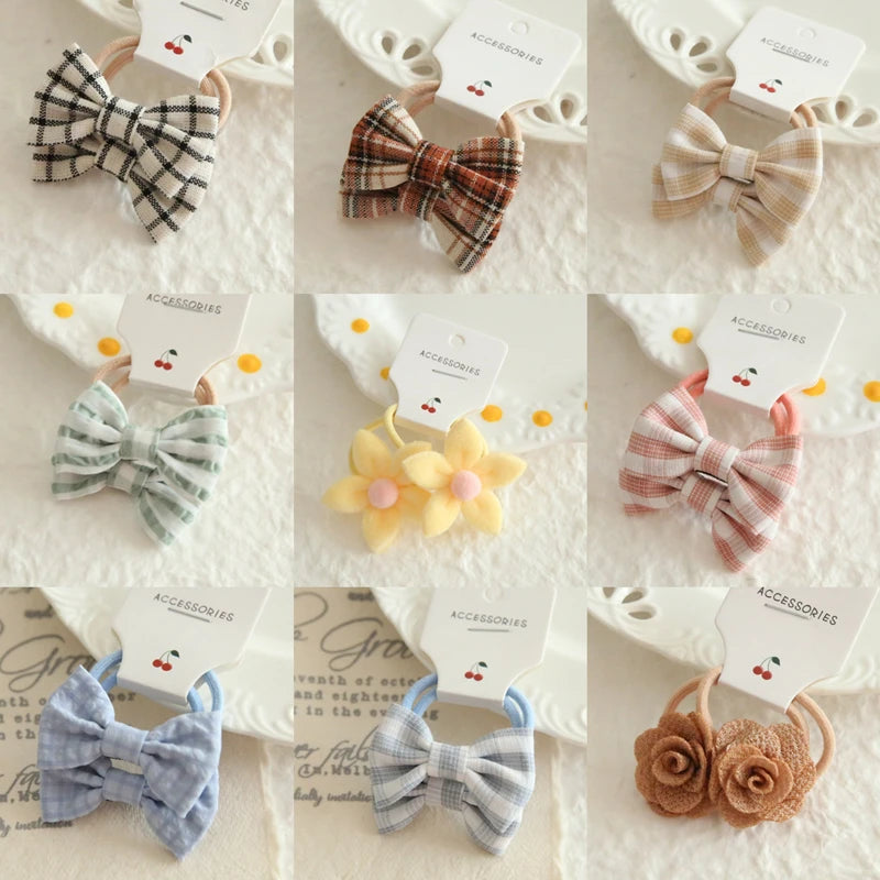 Nine soft cotton hair ties for babies and girls, featuring plaid bows, solid bows, and floral designs in various colors.