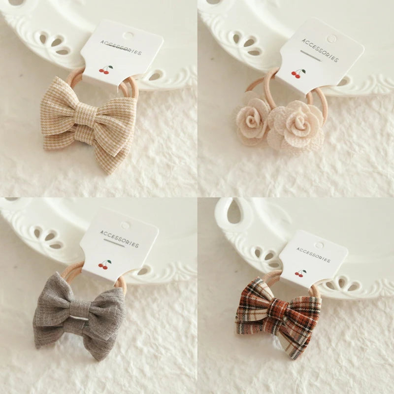 Four pairs of soft hair ties for babies and girls, featuring plaid bows and delicate fabric flowers.