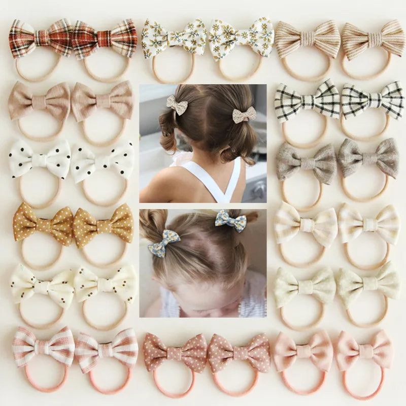 Assorted baby headbands and hair clips with various bow designs in plaid, floral, polka dot, and solid colors.