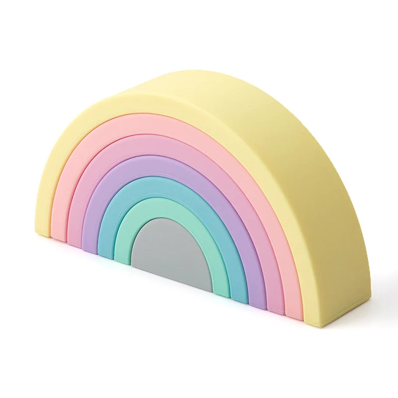 Soft silicone rainbow stacking toy in pastel yellow, pink, purple, blue, green, and gray.