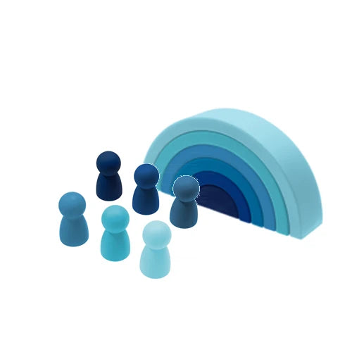 Soft silicone Montessori building blocks in shades of blue, featuring a rainbow arch and six peg dolls.