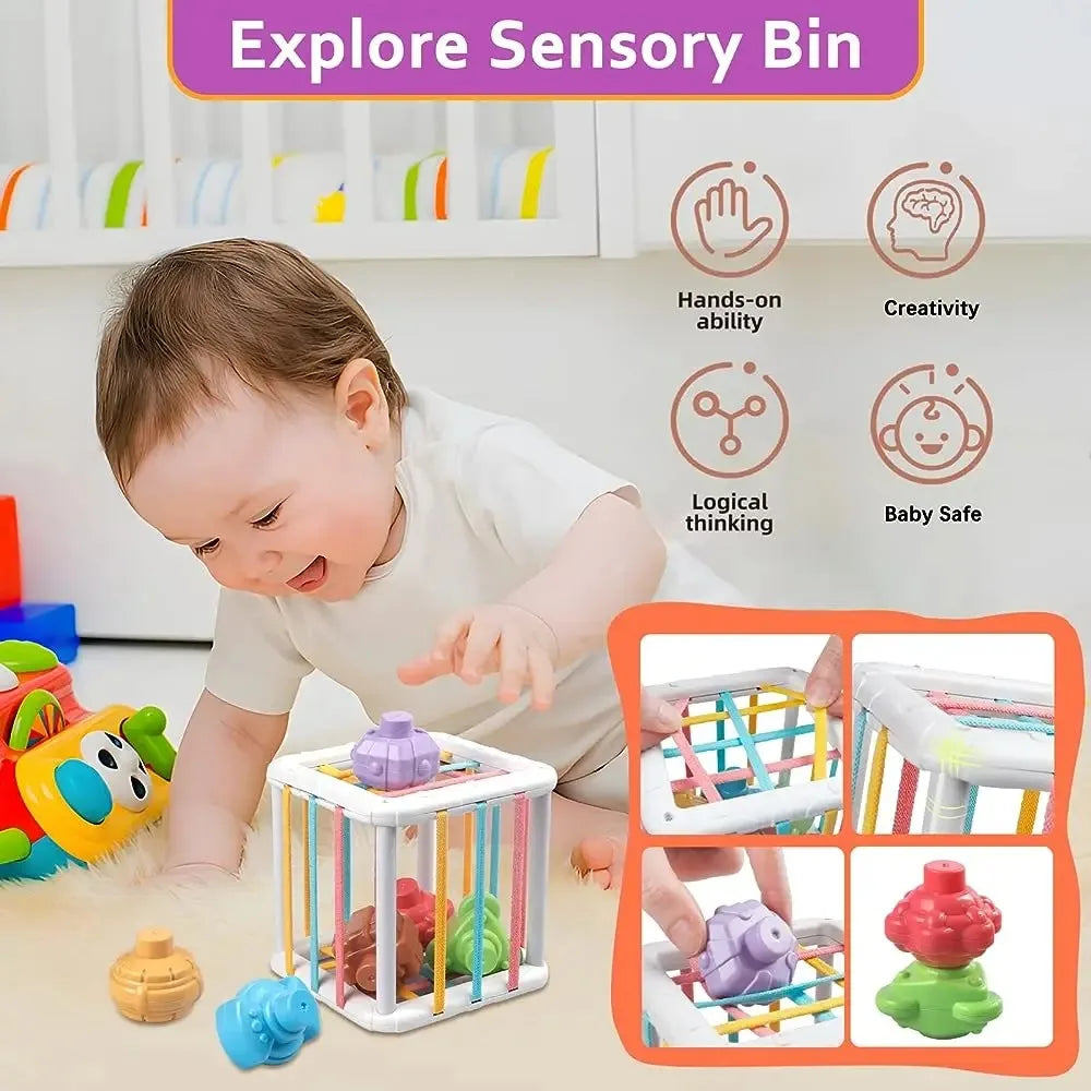 Baby playing with a white Montessori sensory bin featuring colorful elastic bands and various shaped blocks.