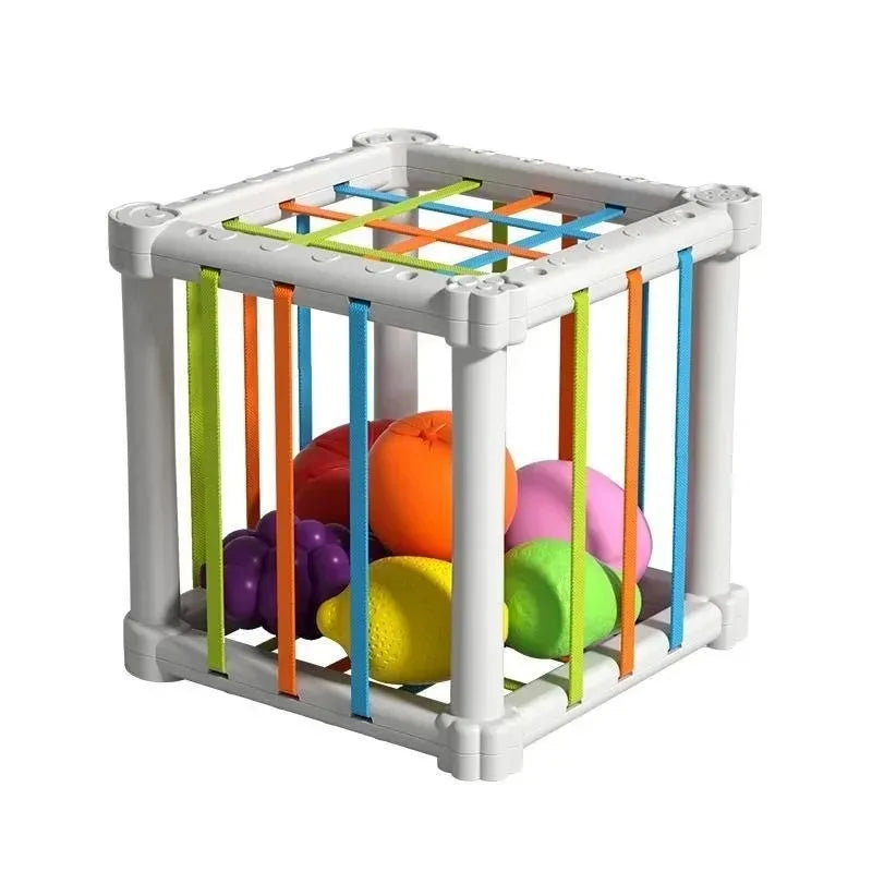 Montessori sorting cube with colorful elastic bands and fruit-shaped blocks for baby motor skill development.