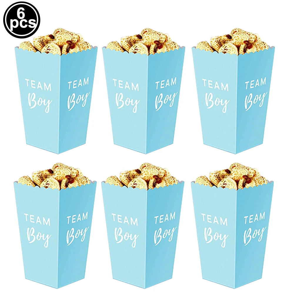 Six light blue paper popcorn boxes filled with snacks, featuring "Team Boy" in white script for gender reveal parties.