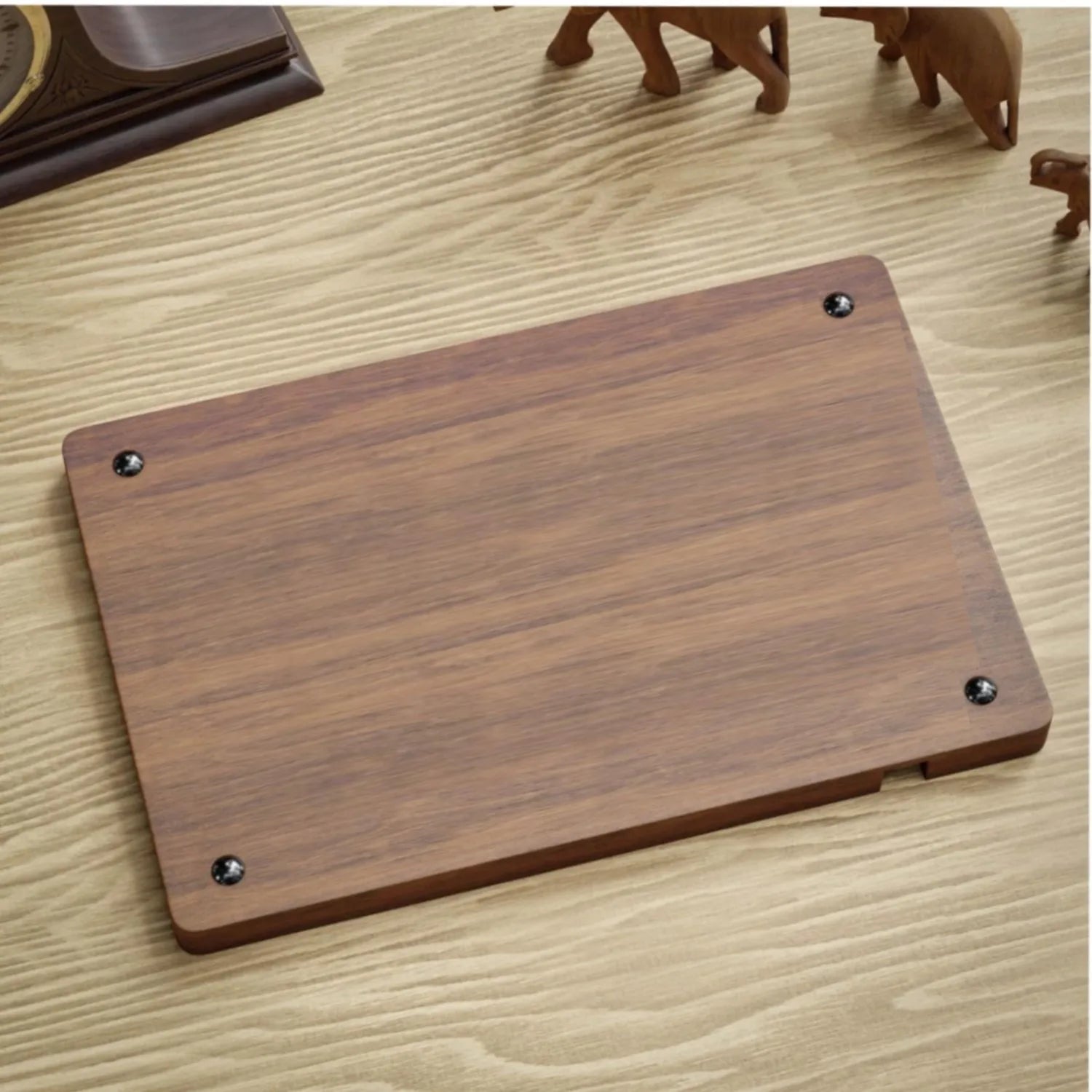 Minimalist dark wood desk organizer with visible grain and black screw accents on a light wooden surface.