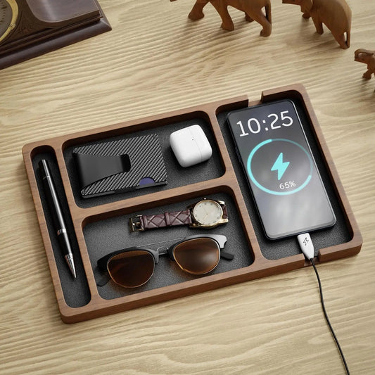 Wooden desk organizer with multiple compartments, holding a phone charging, wallet, earbuds, watch, pen, and sunglasses.