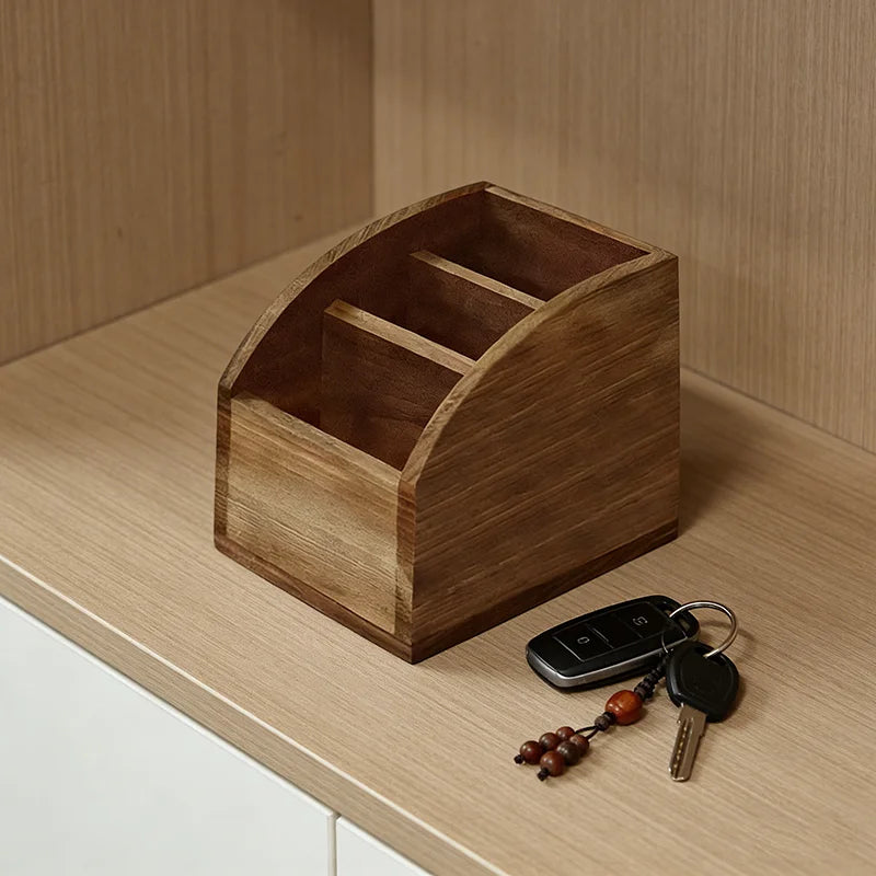 Luxury wooden remote control and accessory organizer with three compartments on a light wood surface.
