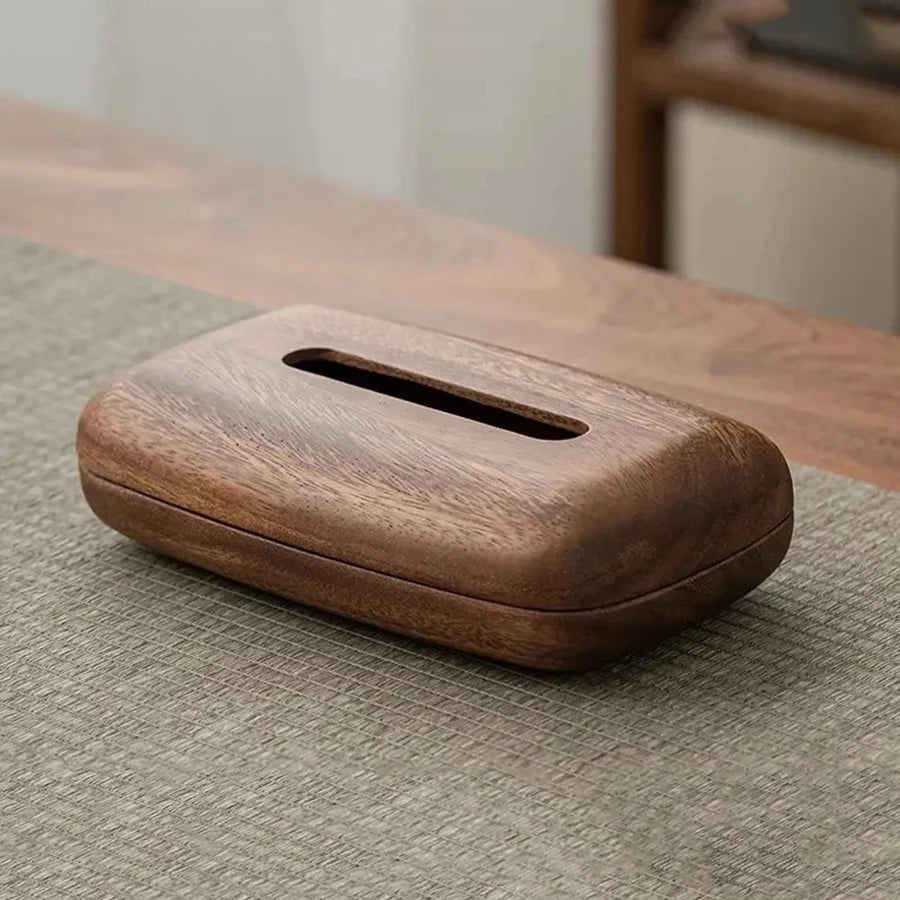 Vintage dark wood tissue box with a smooth, rounded design on a textured gray mat.
