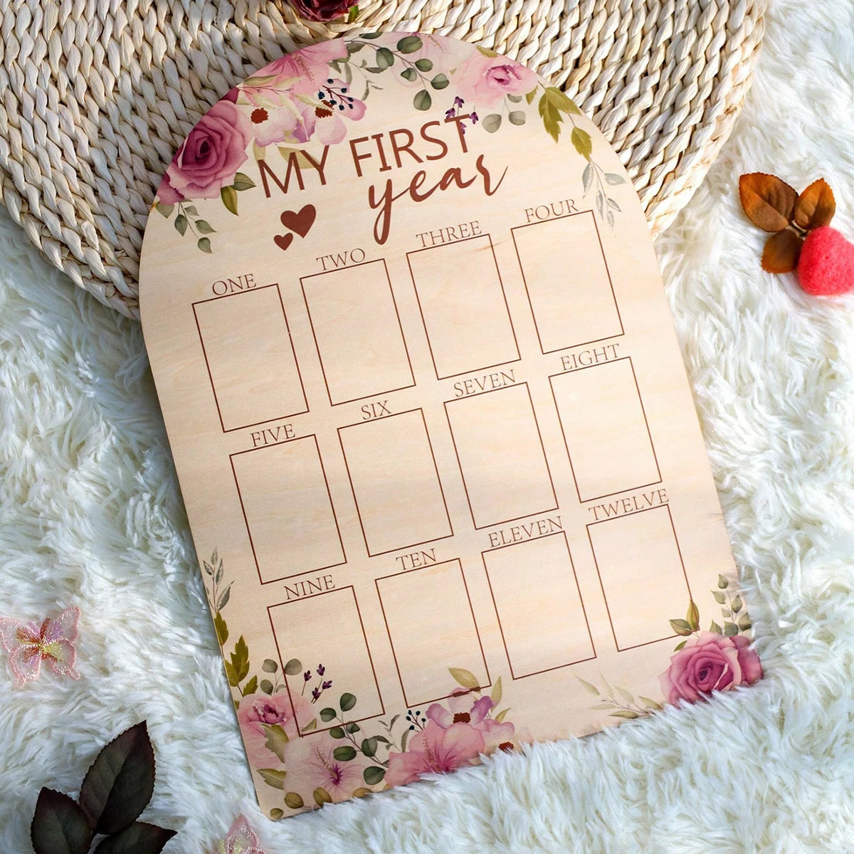 Wooden arched baby milestone board with "MY FIRST year" and floral design.