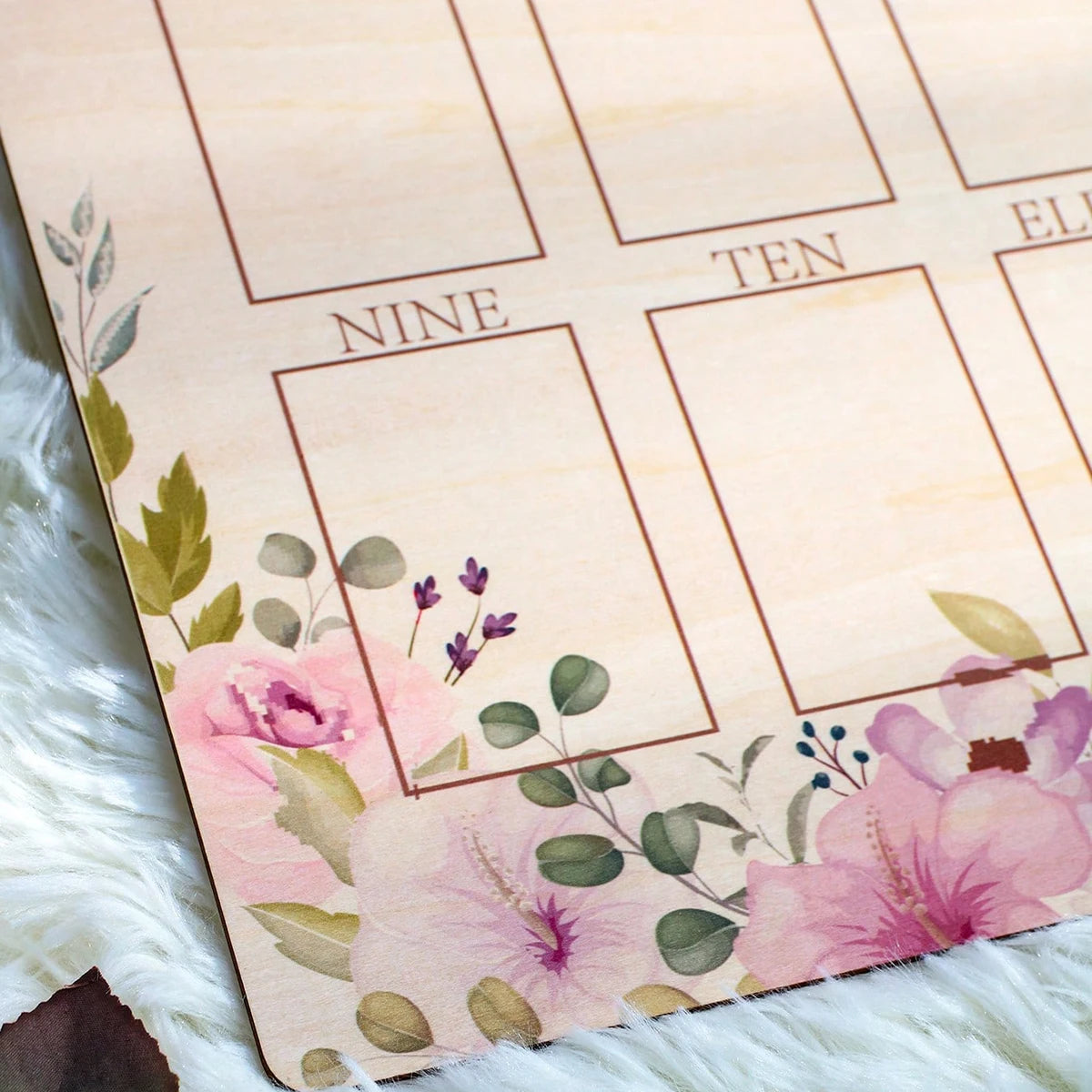 Wooden baby milestone board with floral design, "NINE" and "TEN" months.