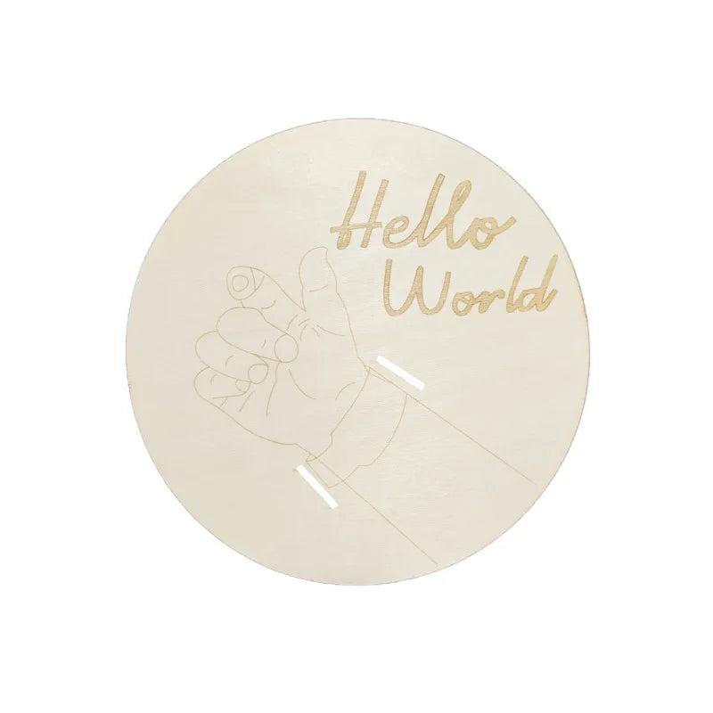 Round natural wood birth keepsake plaque with "Hello World" engraving and baby hand design for hospital bracelet.