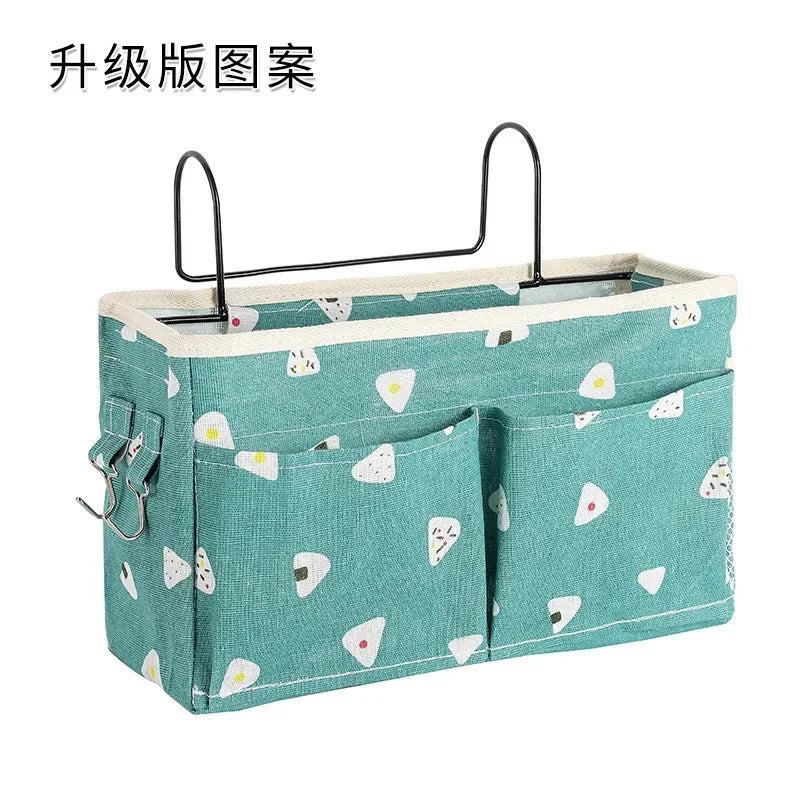 Teal multi-compartment cotton baby crib organizer with white triangle pattern and metal hanging hooks.