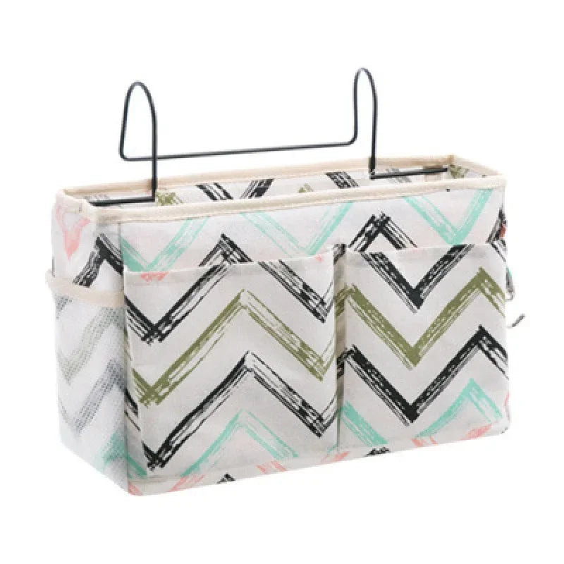 Cotton multi-pocket bedside organizer with colorful chevron pattern and black metal hooks.