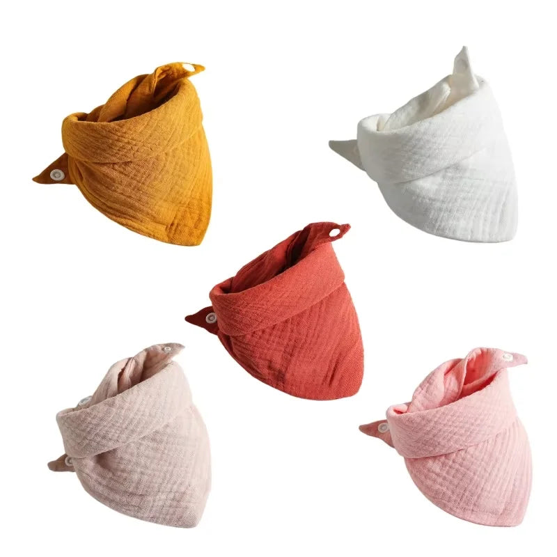 Pack of 5 soft cotton baby bibs in mustard, white, coral, light pink, and blush with snap buttons.