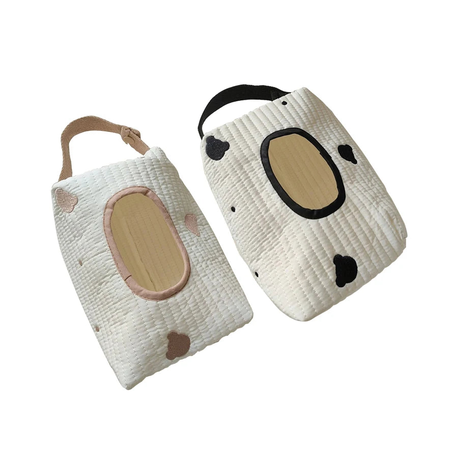 Two quilted cotton hanging tissue and wipe holders, one with pink accents and one with black, featuring animal-inspired designs.