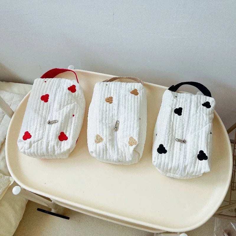Three white quilted cotton hanging tissue and wipe holders with heart designs: red, gold, and black.