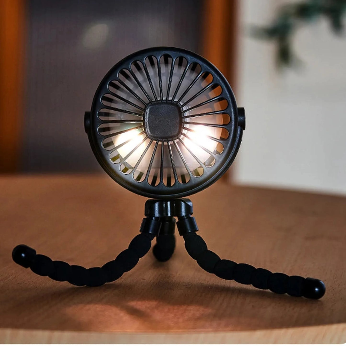 Black portable rechargeable stroller fan with flexible tripod legs and LED lights.