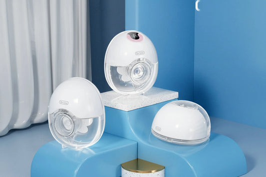 Three white, wearable electric breast pumps with clear collection cups on blue and white risers.