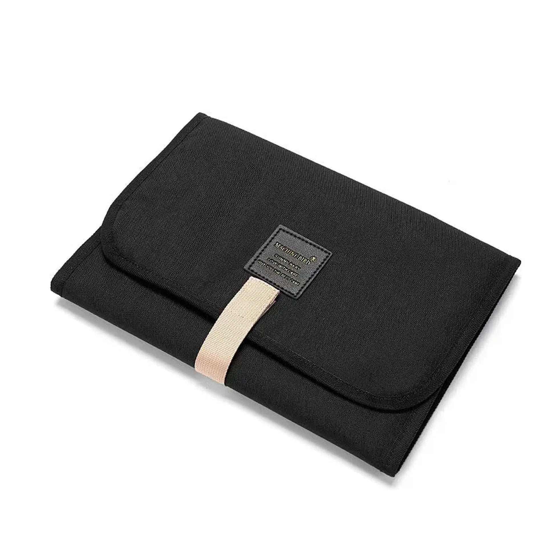 Black portable waterproof baby changing pad with pockets and a beige strap.