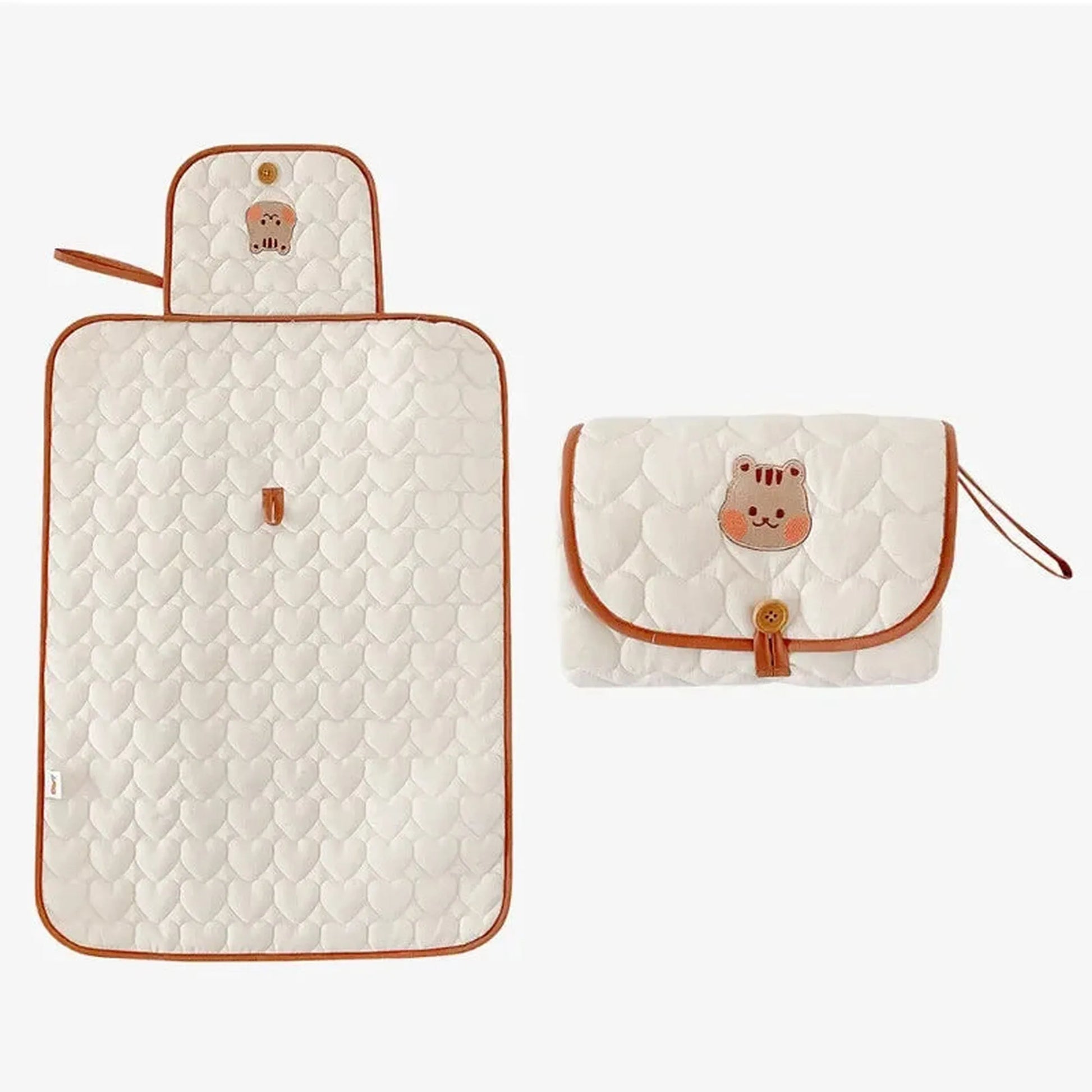 Quilted white portable changing pad with heart pattern and brown trim, shown open and folded with a cute bear design.