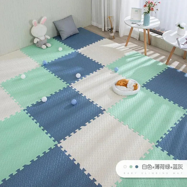 Blue, mint green, and white interlocking EVA foam puzzle play mat for babies.