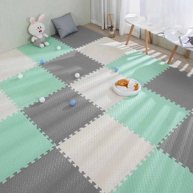 Soft EVA foam puzzle play mat in mint green, gray, and white, with a textured surface.
