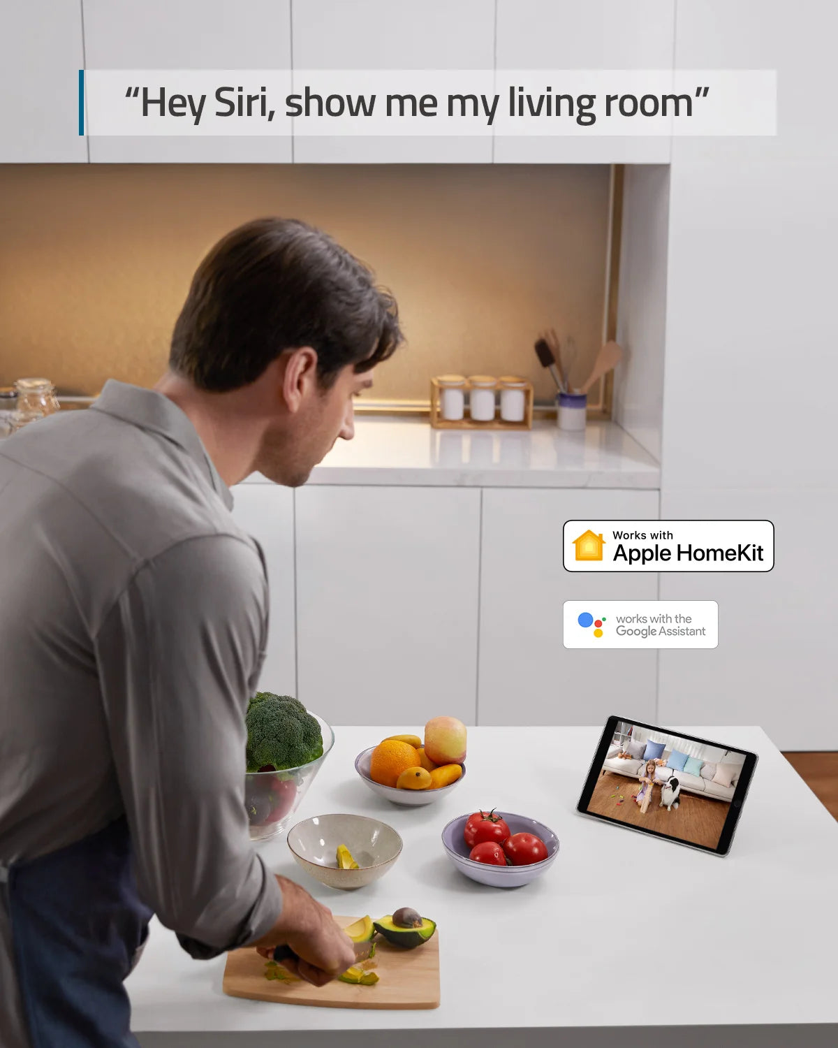 Man cooking in kitchen, viewing live feed from a white 2K smart security camera on a tablet.