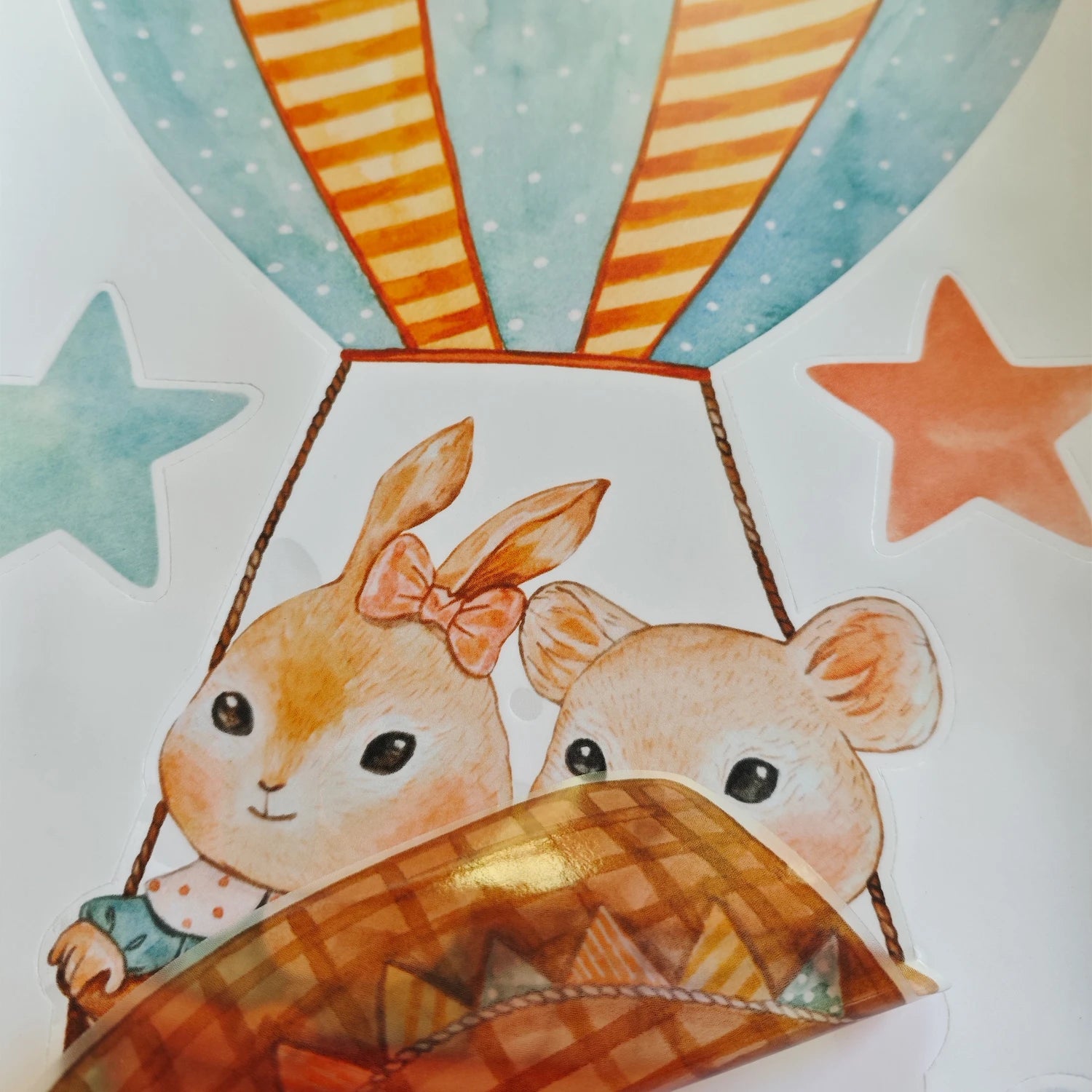 Cartoon animal wall decal featuring a rabbit and bear in a hot air balloon, with stars.