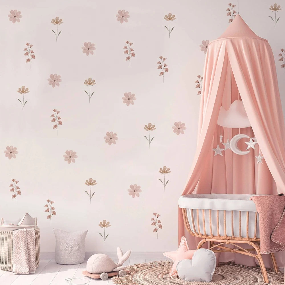 Watercolor flower wall decals in pink and beige for a child's room, with a crib and canopy.